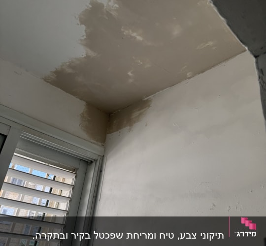 תקרה וקיר עם סימני תיקון צבע